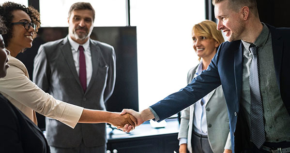 Business professionals shaking hands, symbolizing commercial law and successful transactions.