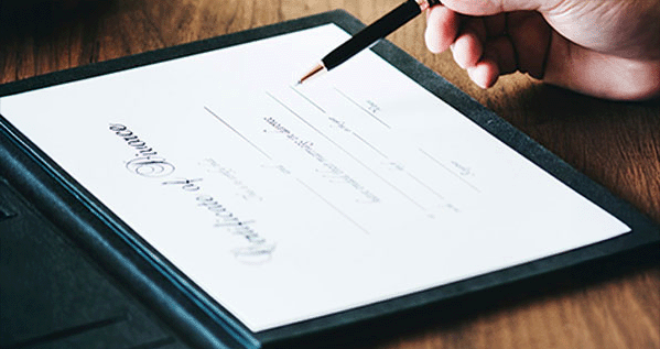 Close-up of a hand signing a document, representing family law services.